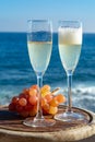 Champagne, prosecco or cava served with pink grape in two glasses on outside terrace with sea view Royalty Free Stock Photo