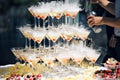 Champagne pyramid on event, party or banquet. cherry in the glass. Dry ice floats