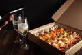 Champagne, tartlets, seafood salads. Cardboard box with food with home delivery. Gift for holiday, party, family dinner. Catering