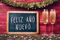 Champagne and text feliz ano nuevo, happy new year in spanish