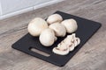 Champignon mushrooms on a black cutting Board. Cook food. Vegetarian, vegan, dietary, proper nutrition, healthy lifestyle. Edible Royalty Free Stock Photo