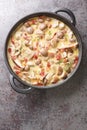 Champignon mushrooms in a creamy wine sauce with bacon and parmesan close-up in a frying pan. Vertical top view Royalty Free Stock Photo