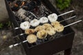Champignon mushrooms are fried on skewers on the grill. Picnic in nature. Close-up Royalty Free Stock Photo