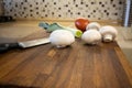 Champignon mushrooms, leek, tomato and knife lie on cutting board