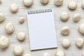 Champignon mushrooms with notepad over white wooden background, top view. Royalty Free Stock Photo