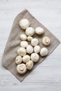 Champignon mushrooms over white wooden background, top view. Royalty Free Stock Photo