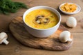 Champignon soup in the white bowl with toast close up on the wooden stand.