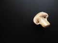 Champignons on a black background. Sliced and whole fresh uncooked raw mushrooms. Cooking mushrooms with a recipe Royalty Free Stock Photo