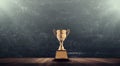 Champion golden trophy placed on wooden table with blackboard ba Royalty Free Stock Photo