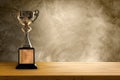 Champion golden trophy placed on wooden table with concrete background. copy space Royalty Free Stock Photo