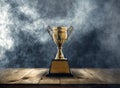 champion golden trophy placed on a wooden table with dark and sm