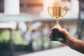 Champion golden trophy for winner in hand background. Success achievement concept. Sport and cup award theme. Best business Royalty Free Stock Photo