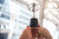Champion silver trophy for runner up winner with sport player hands in sport stadium background. Success and achievement concept. Royalty Free Stock Photo