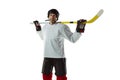 Young male hockey player with the stick on ice court and white background Royalty Free Stock Photo