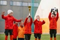 Champions. Group of little boys, children in uniform, football players raising award, trophy. Kids training on outdoor Royalty Free Stock Photo