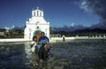 Mother with child sells handmadensouvenirs at church of San Juan