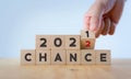Chance concept for business or life in 2022. Hand flips the wooden cubes 2021 to 2022 with text `CHANCE` on beautiful white bac Royalty Free Stock Photo