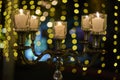 Wedding table decorated with silver chandelier and candles at indoor night luxury wedding
