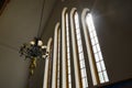 Chandelier before glass windows in small church on sunny day Royalty Free Stock Photo