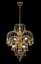 Chandelier for interior of the living room. chandelier decorated with crystals and amber isolated on black background. Royalty Free Stock Photo