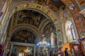 Chandeliers inside an Orthodox church with saints' icons on the walls.