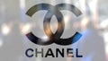 Chanel logo on a glass against blurred crowd on the steet. Editorial 3D rendering