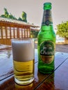 Chang beer bottle and glass full of beer on the table