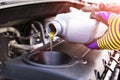 Change the Oil. Hand mechanic in repairing car. Close up oil for car engine. Motor oil pouring to car engine. Refuelling and pouri