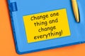 Change one thing and change everything the word is written in black letters on the yellow paper for notes Royalty Free Stock Photo