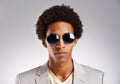 Change the way you look at things. Studio shot of a young man wearing sunglasses against a gray background. Royalty Free Stock Photo