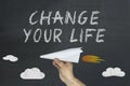 Change your life concept on chalkboard with male`s hand holding paper airplane Royalty Free Stock Photo