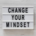 `Change your mindset` words on a lightbox on a white wooden background, top view. Overhead, from above, flat lay Royalty Free Stock Photo