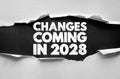 CHANGES COMING IN 2028 concept text revealed through torn paper with rough bold font. Symbol of transformation, vision, innovation Royalty Free Stock Photo