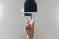 Changing the bulb for led bulb in floor lamp in black colour. On light gray background Royalty Free Stock Photo