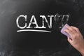 Changing CANT to CAN by erasing letter T with blackboard eraser
