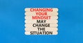 Changing mindset symbol. Concept words Changing your mindset may change the situation on wooden stick on a beautiful blue table