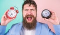 Changing time zones affect health. Does changing clock mess with your health. Man bearded hipster hold two different