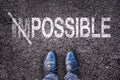 Changing the word impossible on possible on a road with feet Royalty Free Stock Photo