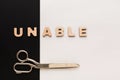 Changing word unable into able with scissors Royalty Free Stock Photo