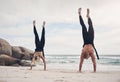 Changing your perspective, changes your experience. a couple doing handstands on the beach. Royalty Free Stock Photo