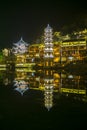 Changsha,China Feb 20, 2014 night illumination lights of FengHuang village chinese pagoda reflect on river