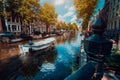 Channel in Amsterdam in autumn sunlight. Boat floating tree-lined canal, vibrant reflections, white clouds in the sky. Netherlands