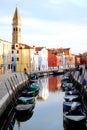 Channel with many colorful bell boats and houses in Burano in Venice in Italy
