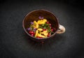 Chanterelles, cow-berries lingonberries, thyme in the clay pipkin dish on black background Royalty Free Stock Photo