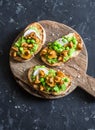 Chanterelles and green peas sandwiches on rustic cutting board top view. Sandwiches with mushrooms and green peas puree.