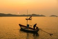 Chanthaburi, Thailand - February, 02,  2020 :Beautiful sunrise over sea with Silhouette of fishermen with yellow and orange sun in Royalty Free Stock Photo