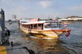 Chao Phraya Express Boat approaching one of the stops along Chao Phraya River, Bangkok