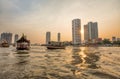 Chao Praya River in Bangkok, buildings and boats at sunset, Thailand