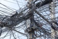 Chaos of cables and wires on an electric pole. Many electrical cable - wire and telephone line on electricity post, Thailand