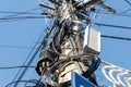 Chaos of many different data cables and network wires messy tangled hanged on concrete pillar pole on urban city street Royalty Free Stock Photo